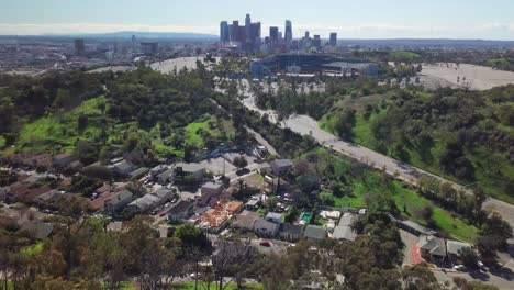 antena del estadio de béisbol encaramado en una colina boscosa con el horizonte del centro de los ángeles en el fondo