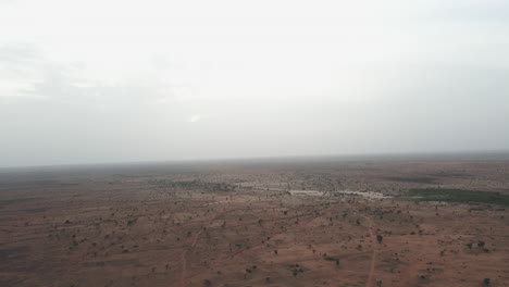 drone spirals sideways over vast terrain in nigeria during daytime, revealing expansive natural landscape with dynamic and cinematic aerial motion