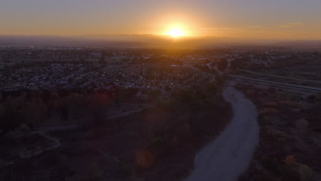 glowing golden sunrise over king city, california - ascending aerial view