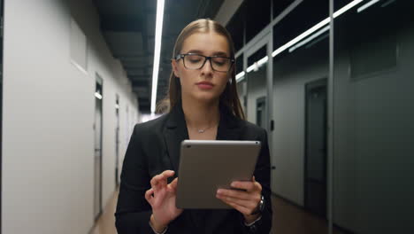 financial manager using tablet computer in office. focused employee surfing web