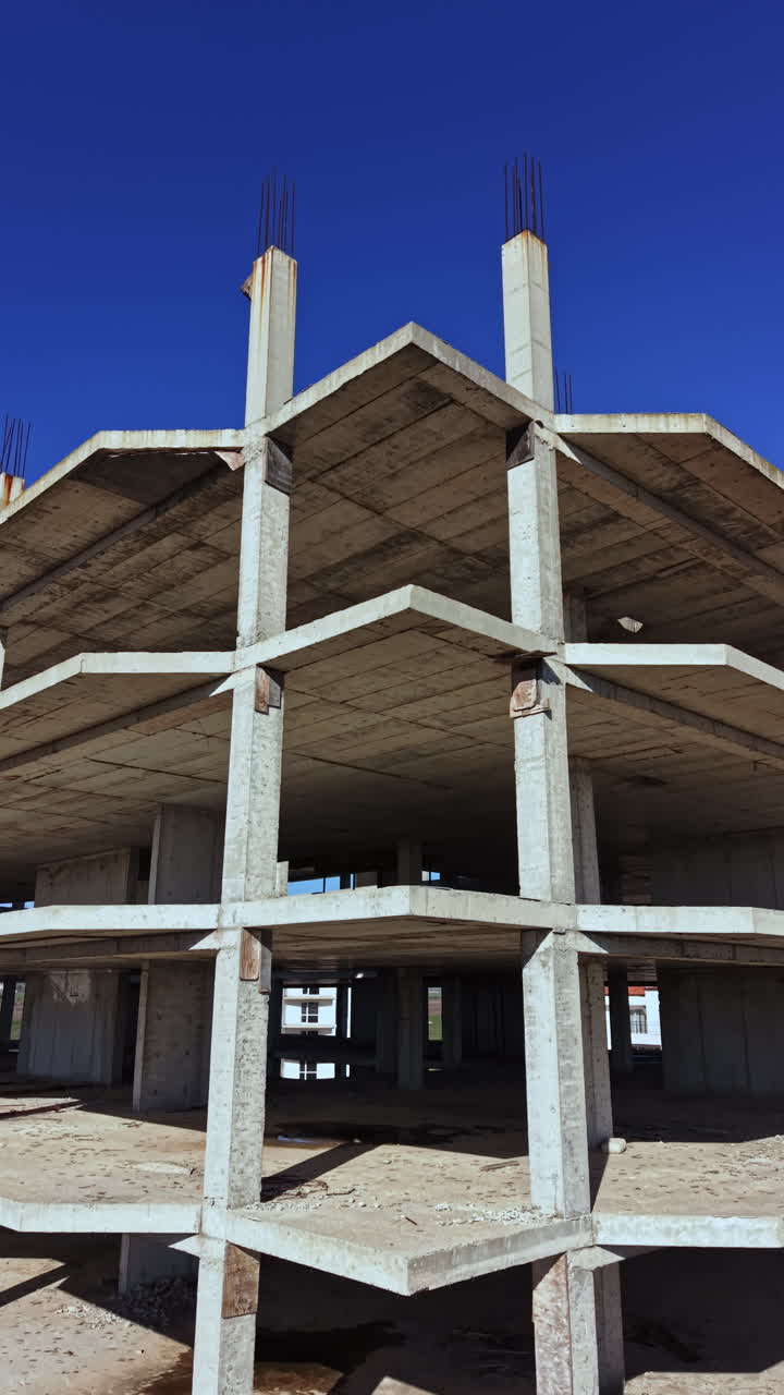 Construcción de un moderno edificio bajo un vasto cielo azul que muestra pilares y vigas de hormigón en un entorno urbano