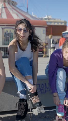 young woman putting on roller skates outdoors with friends