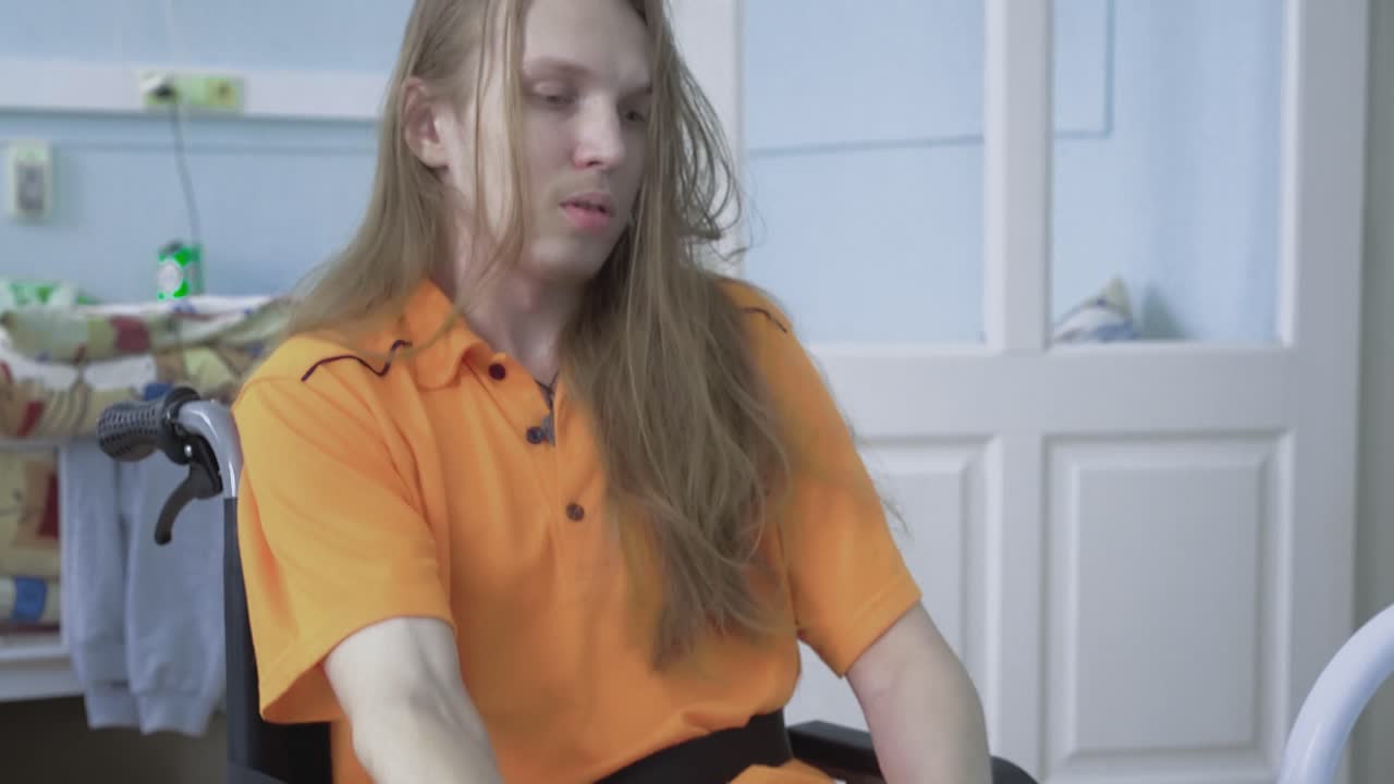 젊은 남자가  ⁇ 체어에 서서 발을  ⁇ 고 있습니다.