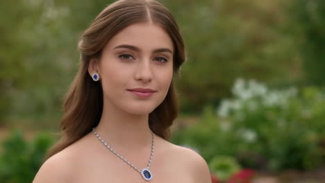 elegant young woman wearing sapphire jewelry in a garden