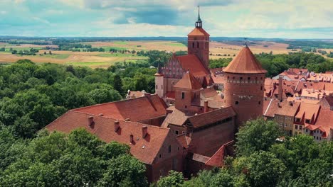 view from a drone on a historic, red-brick castle and church