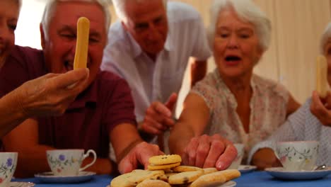 Gruppe-Glücklicher-älterer-Freunde,-Die-Snacks-Essen
