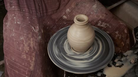 the potter makes a jug of clay. ceramist. a man makes a vase on a potter's wheel