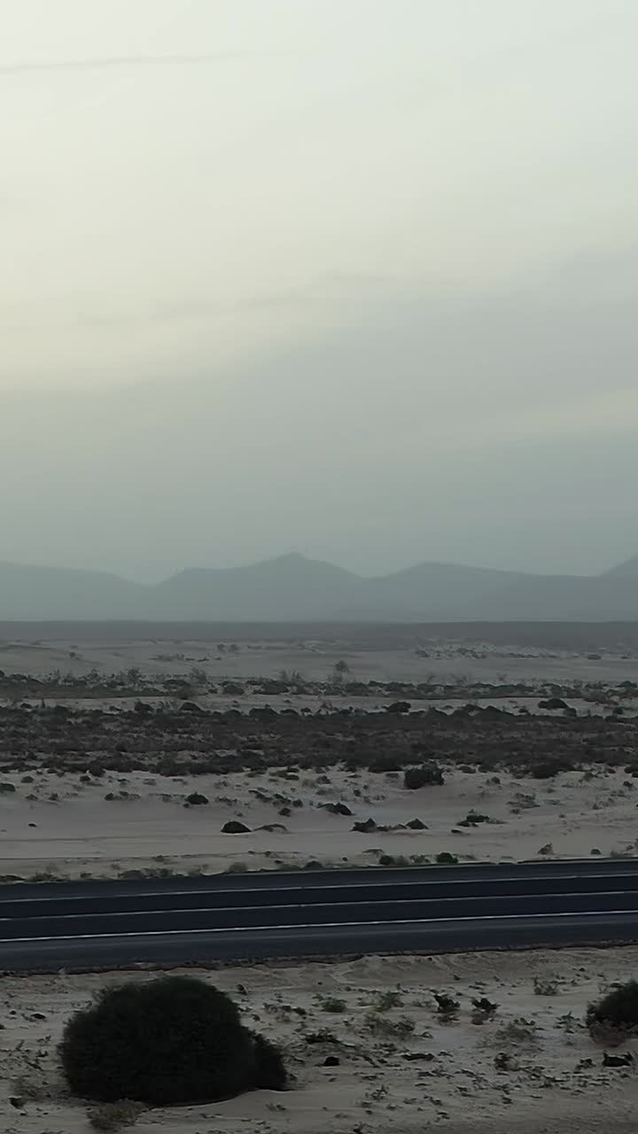 Two People Walking on a Steep Sand Dune Crest