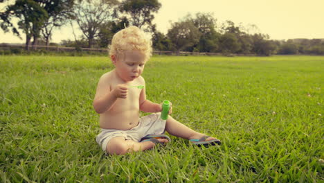 Baby-boy-blowing-soap-bubbles-outdoors