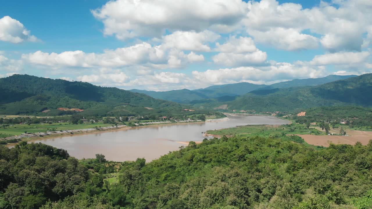 Il possente Mekong circondato da montagne in una giornata di sole con cielo azzurro al confine tra Thailandia e Laos, ripresa con drone