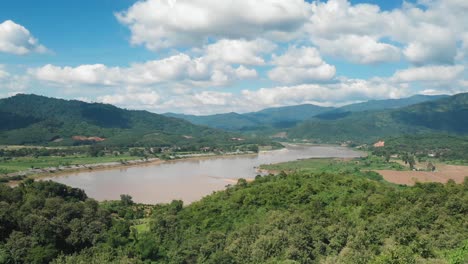 el poderoso mekong rodeado de montañas en un cielo azul día soleado frontera de tailandia y laos, disparo de drones