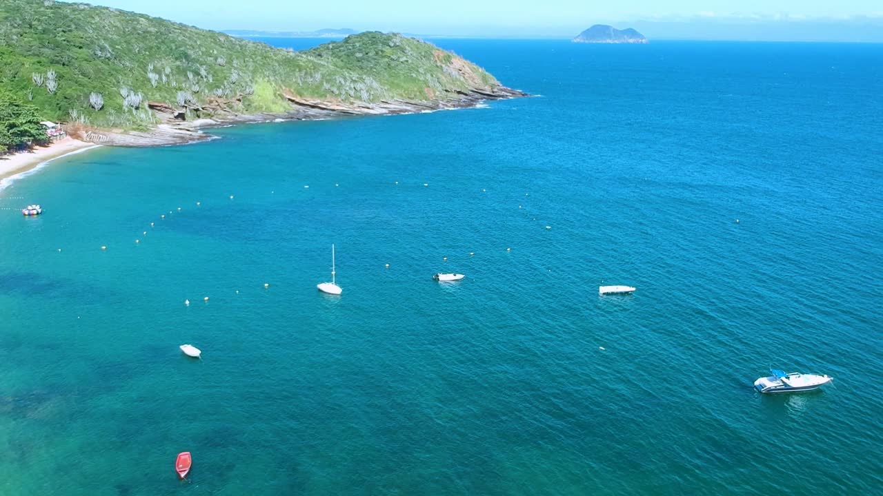 밝고 화창한 날 아름다운 녹색 절벽 옆에 있는 광대한 바다의 청록색 바다에 주차된 요트의 공중