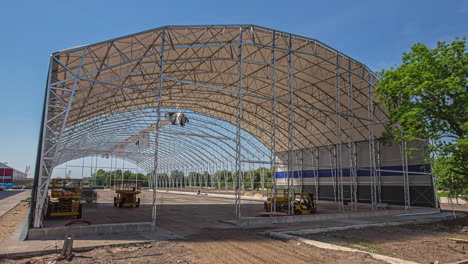 Static-shot-of-metal-frame-of-a-godown-under-construction-throughout-the-day-in-timelapse