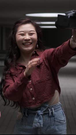 asian female friends bloggers creating content for social media while making a video with a camera.