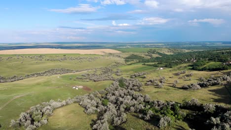 Panoramic-View-Of-The-Green-Terrain-Of-The-Hills-With-Lush-Vegetation-Under-Cloudy-Blue-Sky