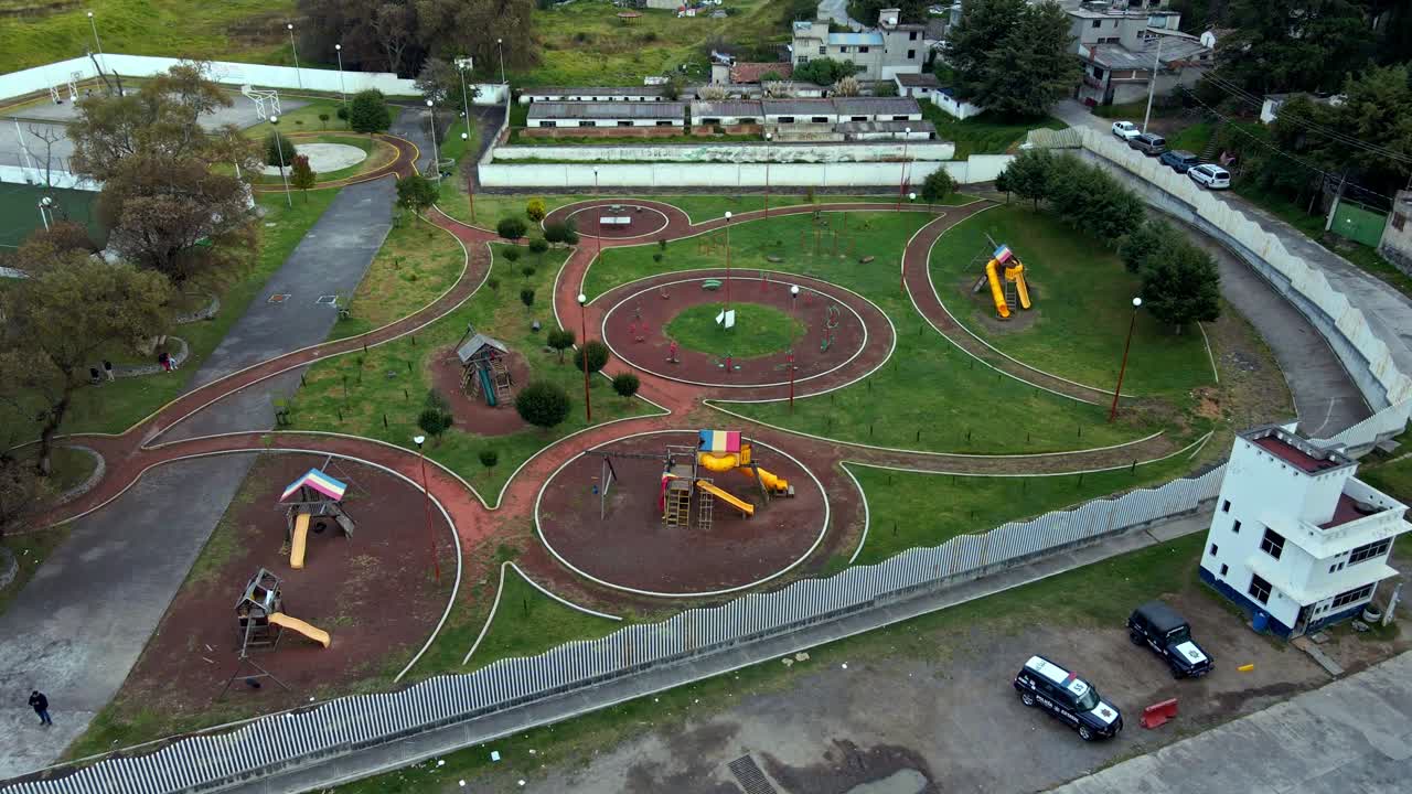 Bird's-eye view of a playground with wrap-around design and friendly walkways in a small village
