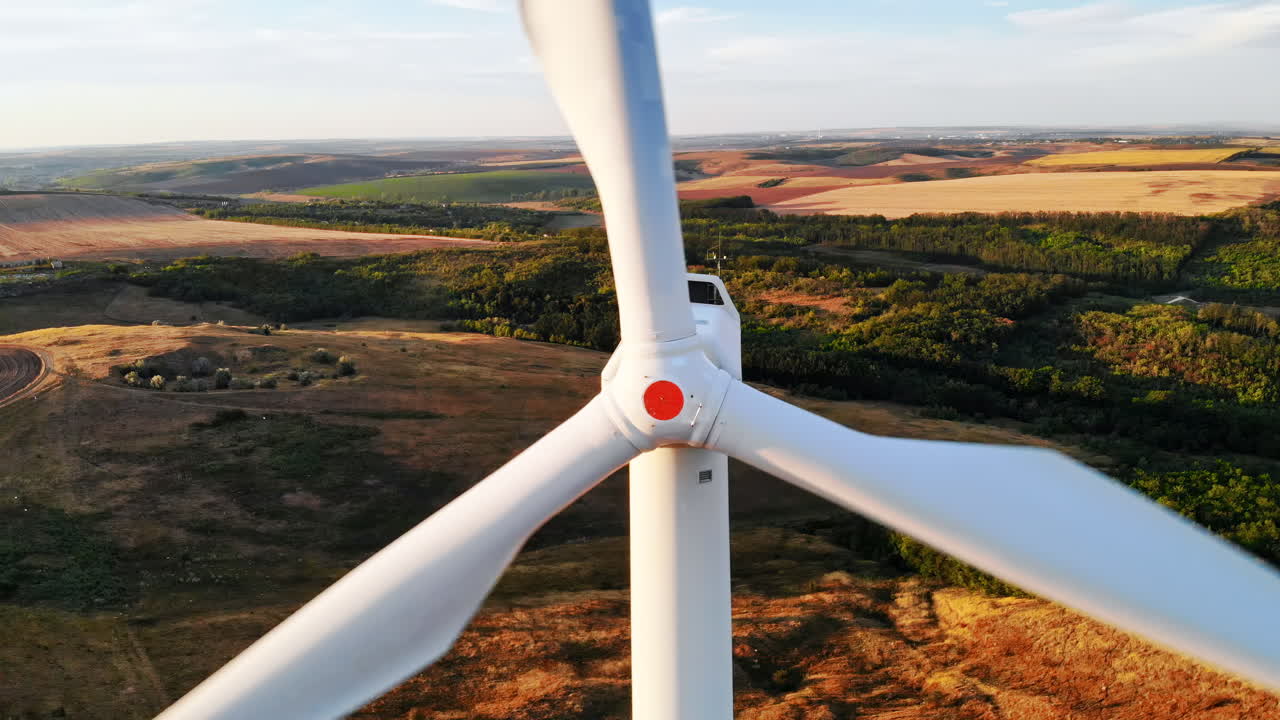 Aerial drone view of wind turbines for energy production located on a field at sunset. Windmill's power generating clean renewable energy for sustainable development. Balti, Moldova