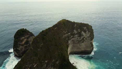 dramatic coastal cliffs and turquoise ocean waves at kelingking beach, nusa penida