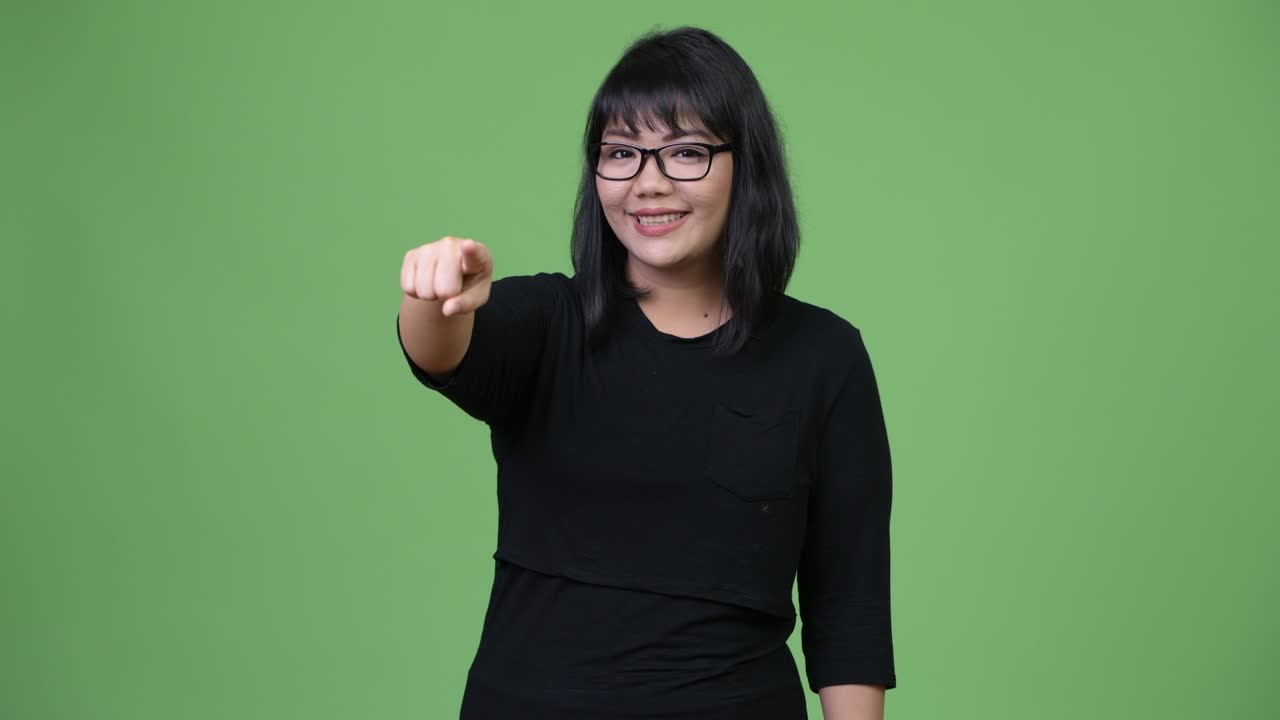 Smuk asiatisk forretningskvinde, der peger på kameraet