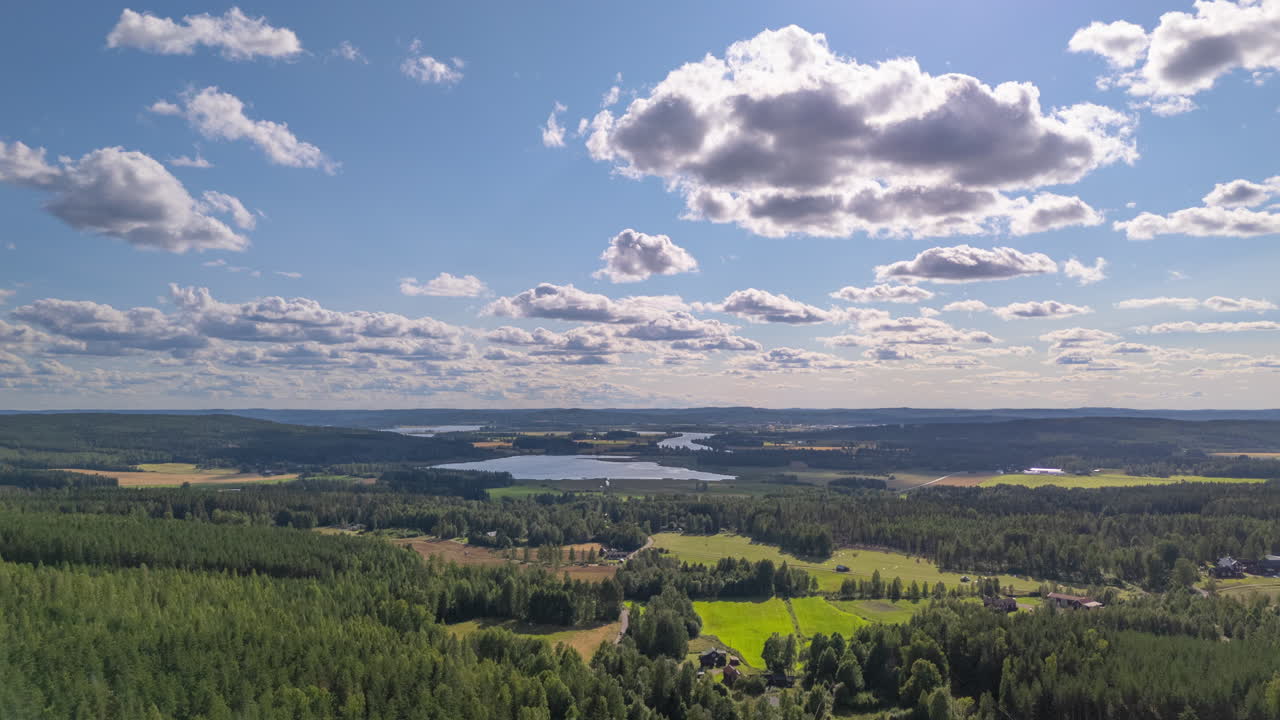 Clouds moving over lush forested Swedish landscape with lakes. Aerial hyperlapse