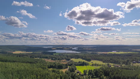 clouds moving over lush forested swedish landscape with lakes. aerial hyperlapse