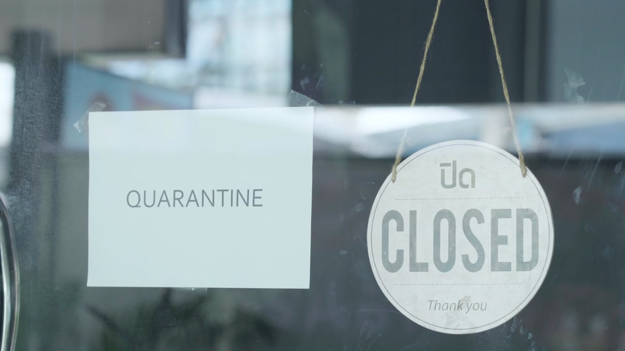Quarantine and Closed Sign on Glass Storefront Door