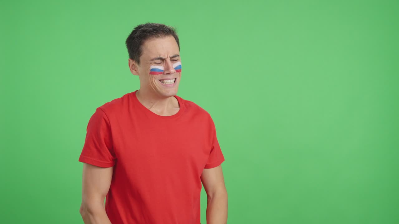 Nervous man cheering for Russia during a match looking away