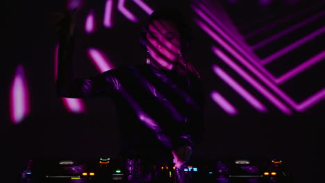 mujer djing en un club con luces púrpuras
