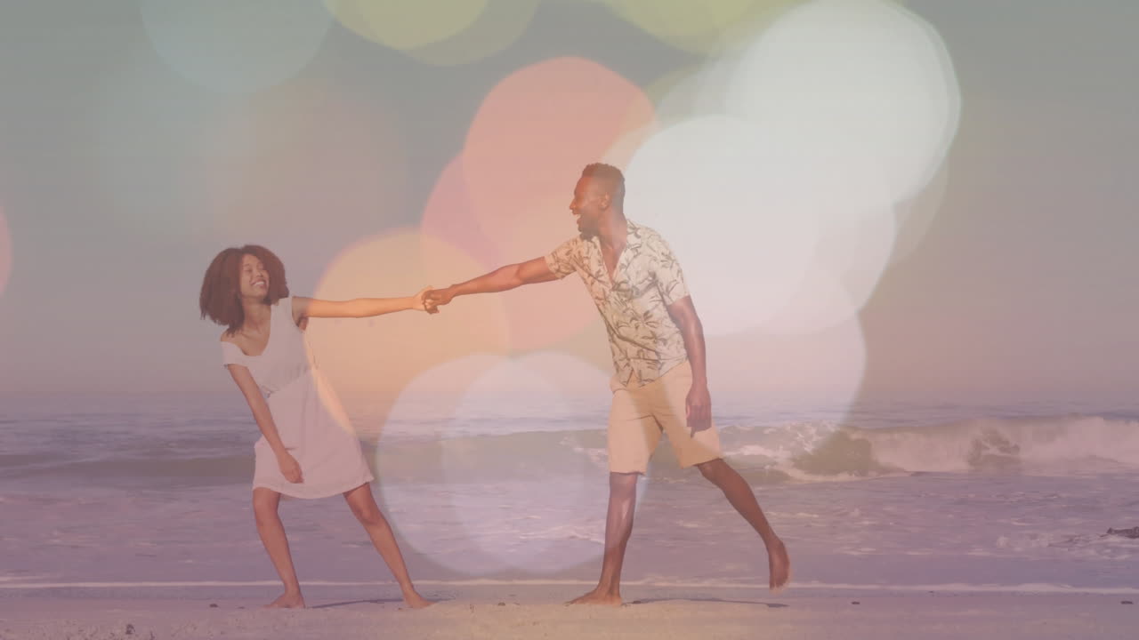 teniendo las manos y sonriendo, pareja en la playa con animación de luces bokeh