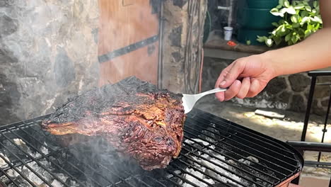 escena en cámara lenta de la carne siendo cortada lista para ser removida de la parrilla con un tenedor