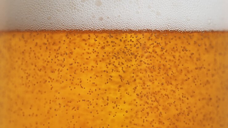 Beer Bubbles Rising Towards The Frothy Beer Head - Fizzy Amber Liquid In Macro