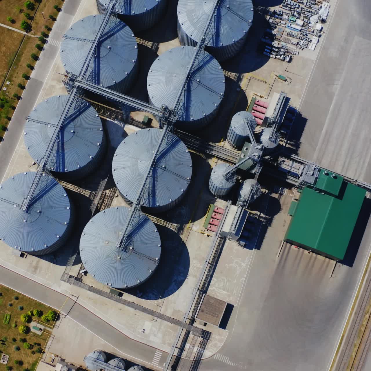 Grain elevator. Top view of steel containers for agriculture products on field. Warehouse granary aluminum containers. Camera rising up slowly.