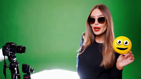 woman with smiley emoji in front of green screen