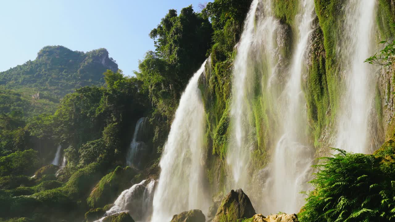 majestuosa cascada en verano con bosque verde y montañas