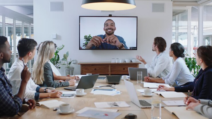 group of business people having conference call meeting in boardroom team leader man chatting to colleagues using online video chat on tv screen discussing ideas in office 4k