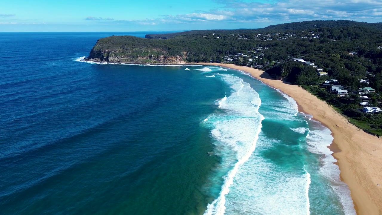 Paesaggio aereo con drone di onde marine che si infrangono lungo la costa sabbiosa di Copacabana Beach con il promontorio rurale di MacMasters sullo sfondo, Central Coast NSW Australia, turismo e natura