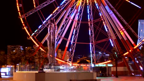 statue of ali and nino on a background ferris wheel at night on the embankment of batumi, georgia
