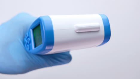 handheld digital thermometer in glove