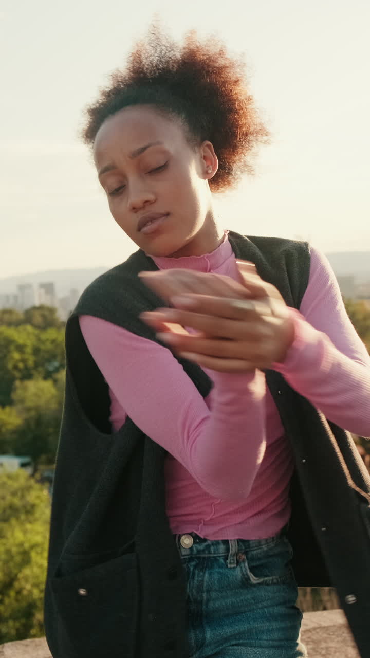 Young Woman Dances on Rooftop at Sunset