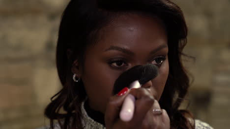 beautiful black, afro american woman powdering her face