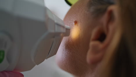 tratamiento de primer plano de la piel de la mujer utilizando un dispositivo de cosmetología moderno en el salón de belleza.