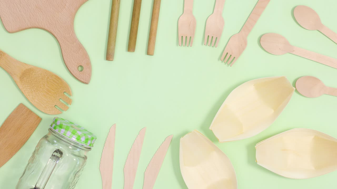 친환경 대나무 주방 도구 프레임은 밝은 초록색 배경에서 움직입니다.