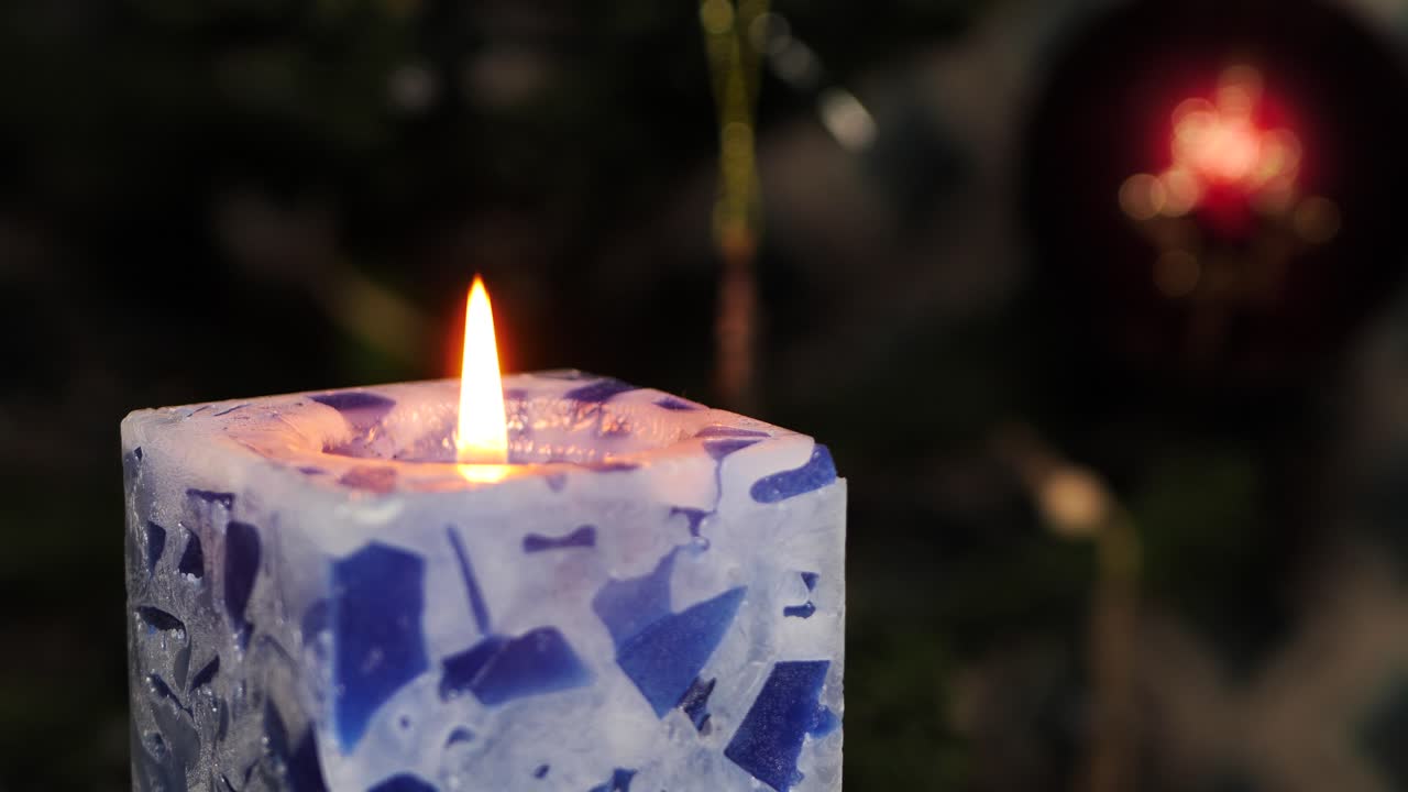 el árbol de navidad artificial gira con luces, la vela de navidad está encendida