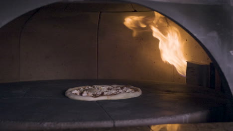 pizza spinning in the stone oven in a restaurant kitchen