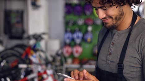 Mechanic-using-mobile-phone-in-workshop