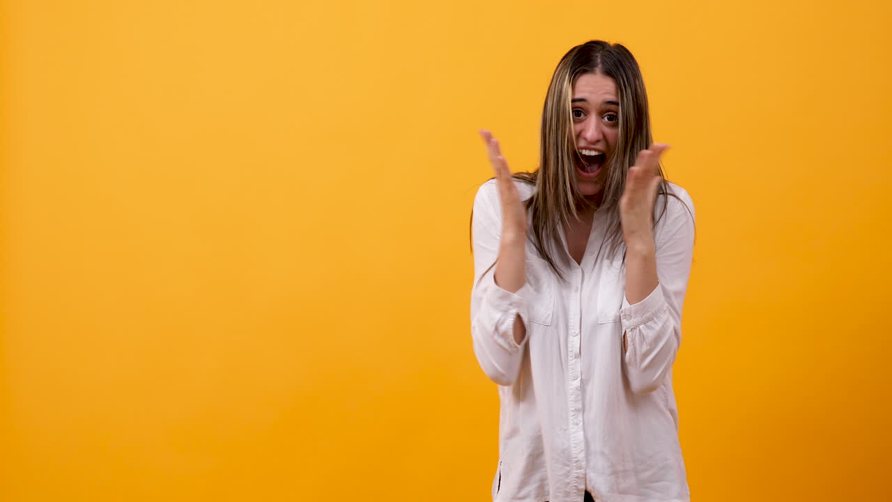 Excited woman celebrating success on yellow background