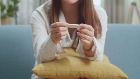 young asian woman holding pregnancy test