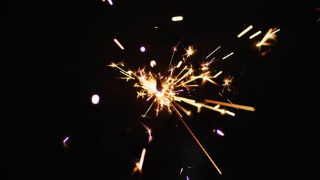 una chispa de fiesta encendida brillando sobre un fondo negro