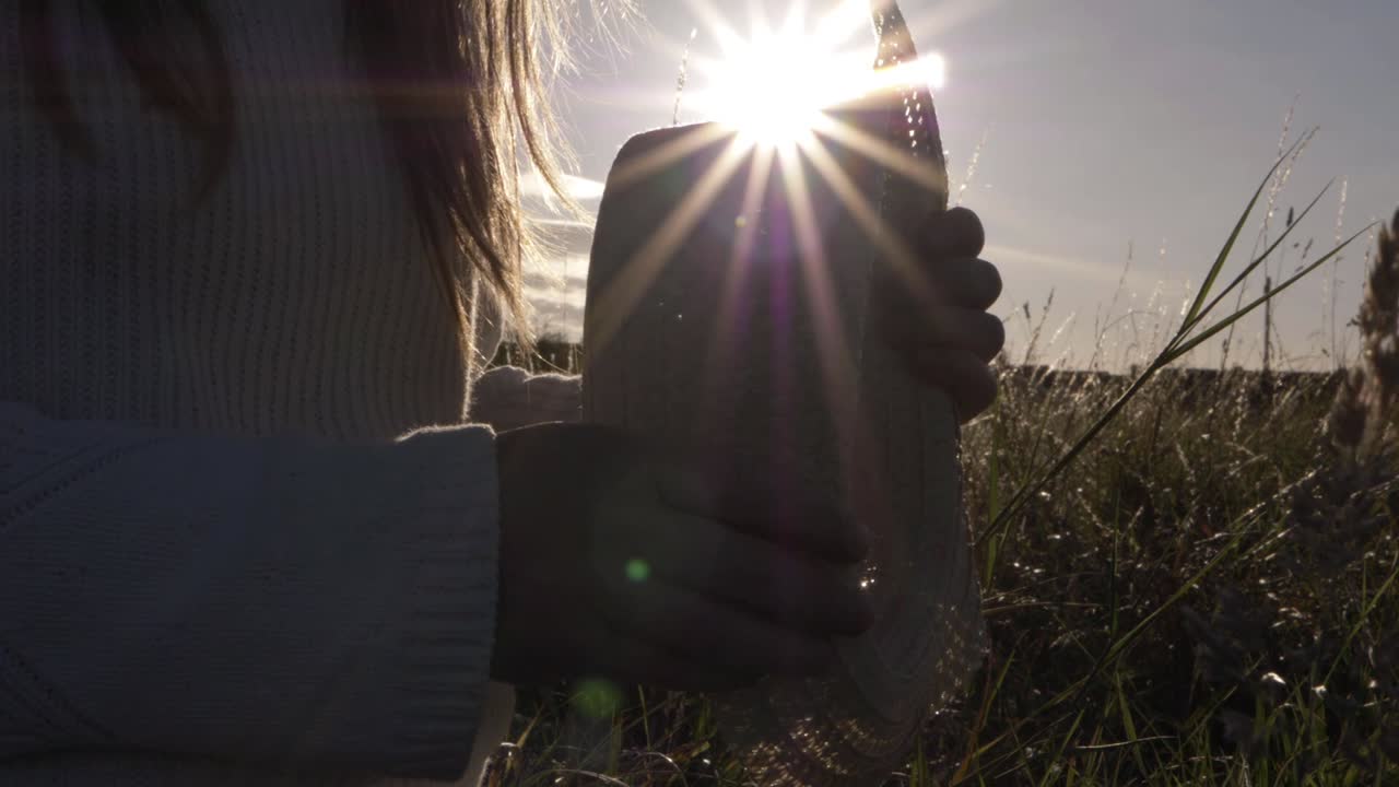 Woman holding straw hat at sunset silhouette close up shot