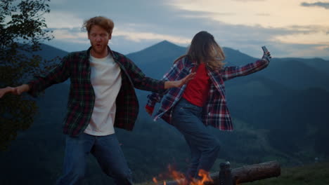 happy couple dance evening in mountains nature. tourist family have fun outside.